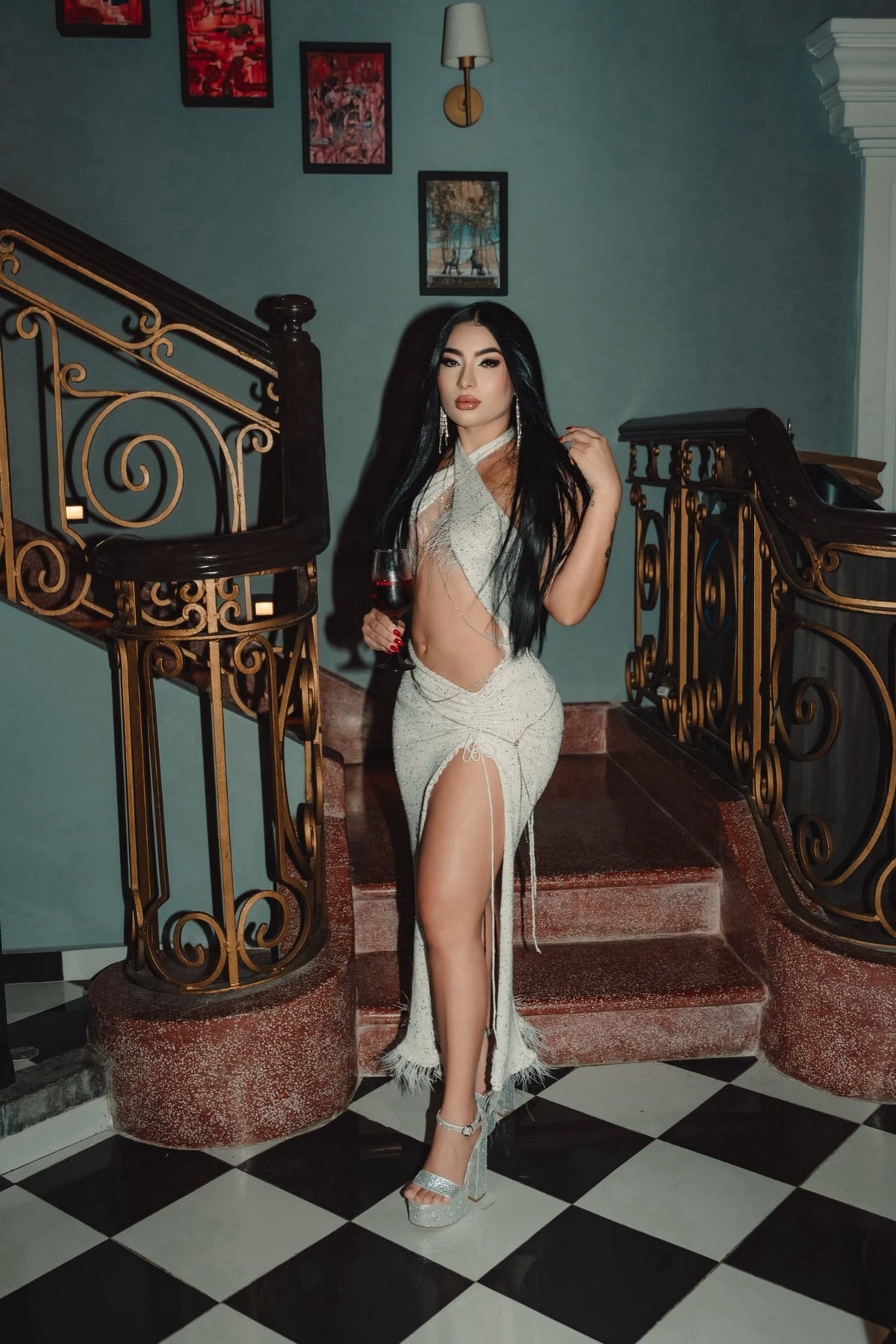 Clienta con vestido color marfil en una escalera con barandal dorado